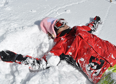 男性が雪の上に仰向けに寝転がっている様子